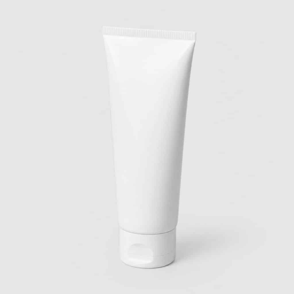 Tube de crème réparatrice posé sur fond neutre clair