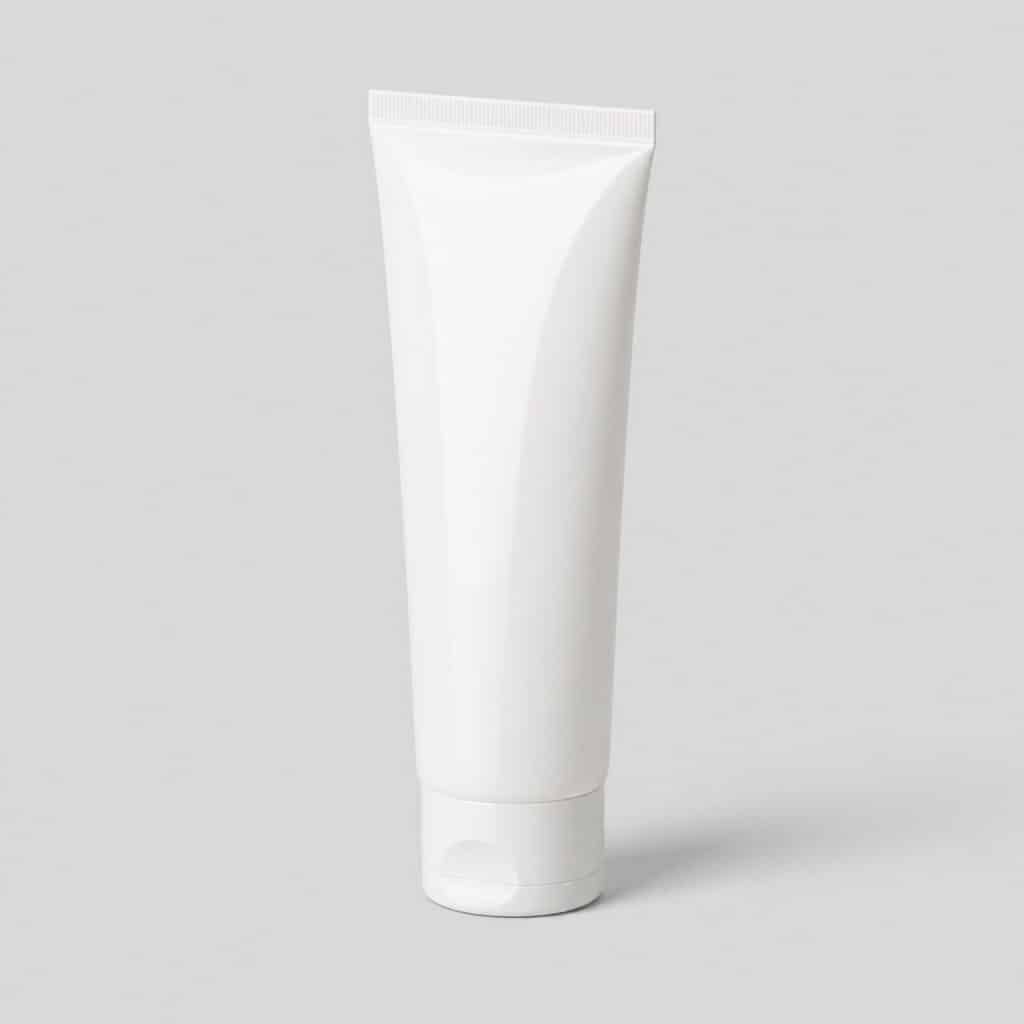 Tube de baume réparateur posé sur fond neutre clair