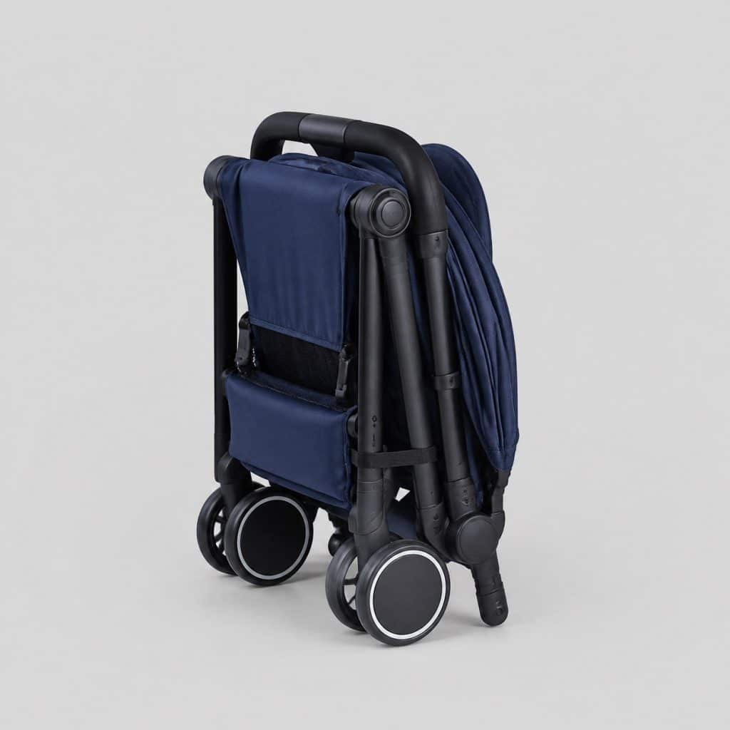 Poussette ultra-compacte bleu marine pliée au format cabine